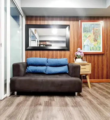 a living room with a couch and a mirror at Azure Paranaque near Airport in Manila