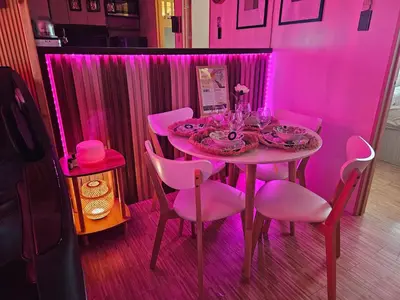 a pink dining room with a table with pink chairs at Dlighful Pad's MassageChair FreeParking Bar Park Garden in Manila