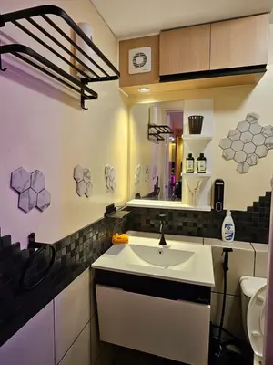 a bathroom with a sink and a mirror at Dlighful Pad's MassageChair FreeParking Bar Park Garden in Manila