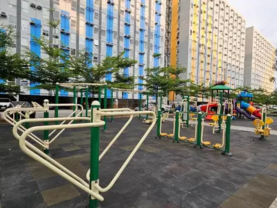a row of playground equipment in a city at Dlighful Pad's MassageChair FreeParking Bar Park Garden in Manila