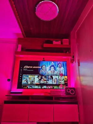 a television in a room with pink lights at Dlighful Pad's MassageChair FreeParking Bar Park Garden in Manila