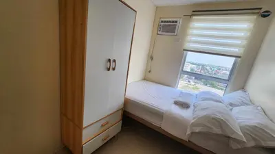 a small bedroom with a bed and a window at URBAN DECA R1125 Ortigas SM EAST in Manila