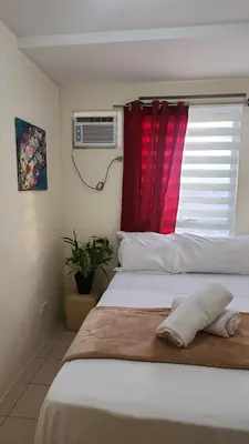 a bedroom with a bed with a red window at URBAN DECA R1125 Ortigas SM EAST in Manila