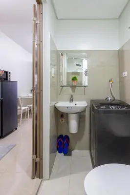 a bathroom with a sink and a toilet and a mirror at Oasis Urban Stay 2 in Manila