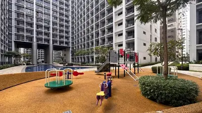 a playground in front of a tall building at Oasis Urban Stay 2 in Manila