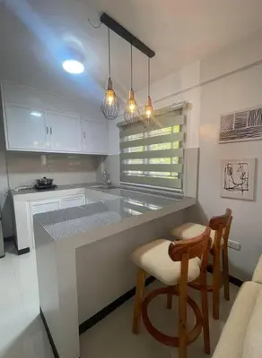 a kitchen with a counter and two chairs in it at House Tahhánne in Amadeo