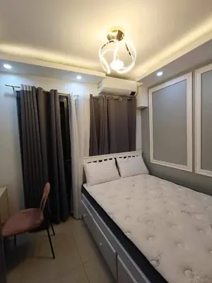 a bedroom with a bed and a chandelier at The SK home at the shore in Manila