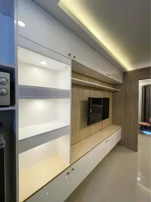 a walk in closet with white shelves and a tv at The SK home at the shore in Manila