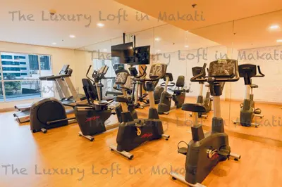 a gym with a bunch of treadmills and exercise bikes at Cozy Loft in Makati in Manila