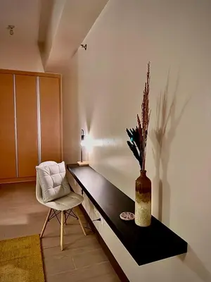 a room with a desk with a chair and a vase at Cozy Loft in Makati in Manila