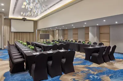a conference room with tables and chairs and a screen at Grand Westside Manila Bay in Manila