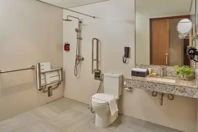 a bathroom with a toilet and a sink at Grand Westside Manila Bay in Manila