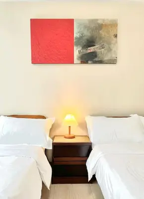 a bedroom with two beds and a table with a lamp at Spacious 2-BR unit in One Uptown Residences in Manila