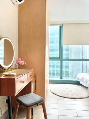 a bedroom with a desk and a mirror and a bed at Spacious 2-BR unit in One Uptown Residences in Manila