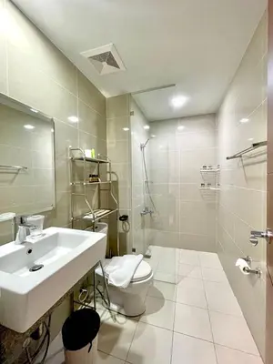 a bathroom with a sink and a toilet and a shower at Spacious 2-BR unit in One Uptown Residences in Manila