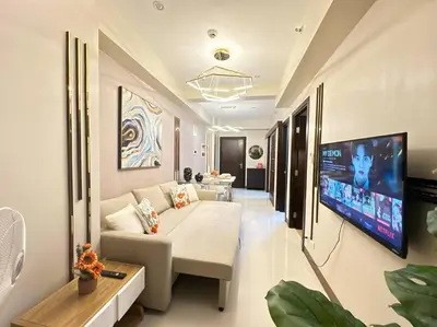 a living room with a couch and a flat screen tv at Executive Stay with Balcony & Malls at Uptown BGC in Manila