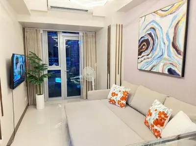 a living room with a white couch and a painting at Executive Stay with Balcony & Malls at Uptown BGC in Manila