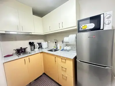 a kitchen with a stainless steel refrigerator with a microwave at Executive Stay with Balcony & Malls at Uptown BGC in Manila