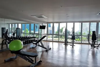 a gym with treadmills and exercise equipment in a building at Executive Stay with Balcony & Malls at Uptown BGC in Manila