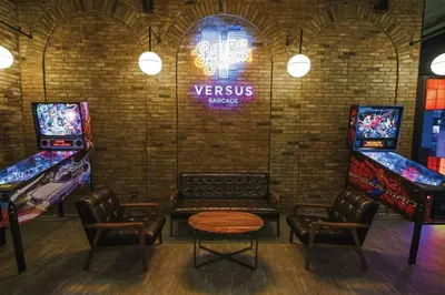 a room with two arcade games and a table and chairs at Executive Gem beside Malls and Bars at Uptown BGC in Manila