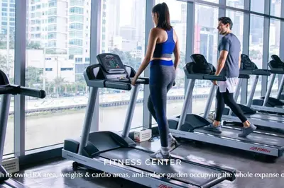 a man and a woman on a treadmill in a gym at Skyloft Acqua Private Residences in Manila