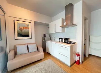a living room with a couch and a kitchen at Skyloft Acqua Private Residences in Manila