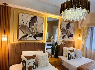 a bedroom with two beds and a chandelier at Jai Suite K&J Cozy Place Staycation in Manila