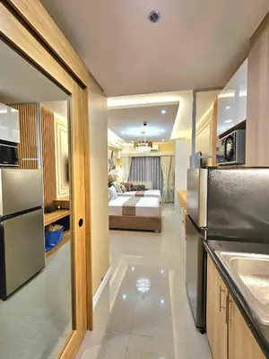 a room with a kitchen and a bedroom with a bed at Jai Suite K&J Cozy Place Staycation in Manila