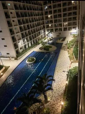 a large building with a swimming pool in front of a building at Jai Suite K&J Cozy Place Staycation in Manila