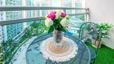 a glass table with a vase of flowers on a balcony at Stunning 1-Bed Apartment in Paranaque in Manila