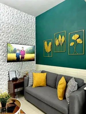 a living room with a couch and a wall with paintings at Lovely Condo in Uptown, BGC - Soleil Pacific Suite in Manila