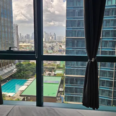 a window with a view of a pool from a building at Lovely Condo in Uptown, BGC - Soleil Pacific Suite in Manila