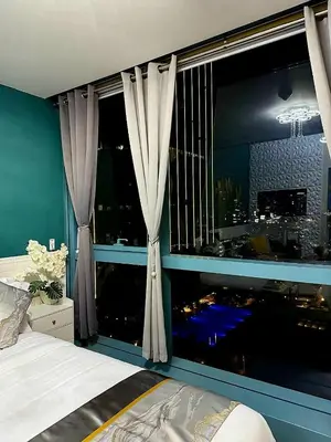 a bedroom with a window with a view of a city at Lovely Condo in Uptown, BGC - Soleil Pacific Suite in Manila