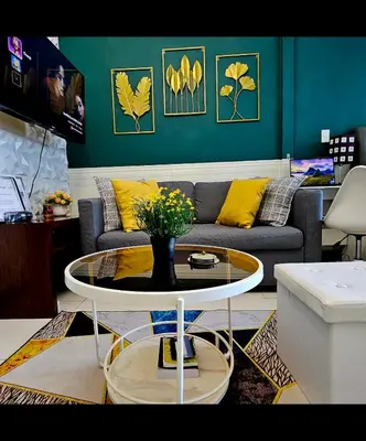 a living room with a couch and a table with yellow pillows at Lovely Condo in Uptown, BGC - Soleil Pacific Suite in Manila