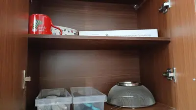 a wooden cupboard with a pot on a shelf at Condo in Parañaque in Manila