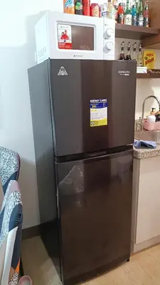 a microwave sitting on top of a refrigerator at Condo in Parañaque in Manila