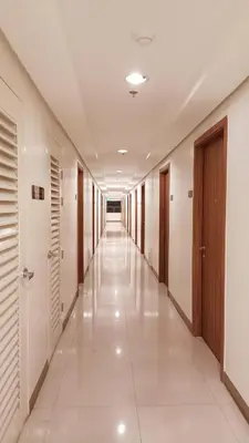 a corridor of an office building with white floors and doors at Condo in Parañaque in Manila
