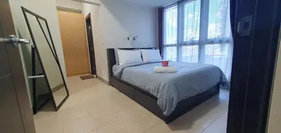 a bedroom with a bed and a window at 2BR at the FORT BGC near Malls, Restaurants & Shops in Manila