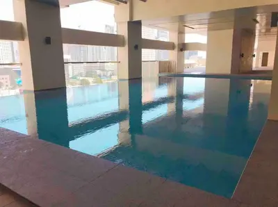 a swimming pool with blue water in a building at Loft Style Condo Unit in Makati with Netflix WIFI in Manila