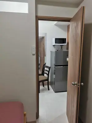 a room with a door to a kitchen with a microwave at Moa SHORE 3 TOWER 2 RESIDENCE in Manila