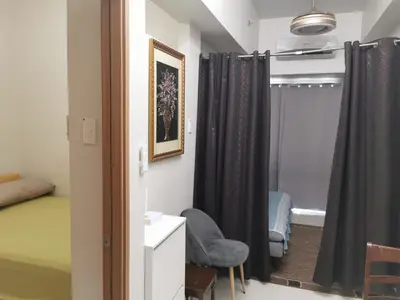 a room with a bed and a chair and a window at Mao shore 3 residence tower 2 in Manila