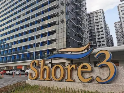 a store sign in front of a large building at Mao shore 3 residence tower 2 in Manila
