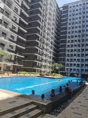 a swimming pool in front of some tall buildings at Shore 3 residence Moa Pasay in Manila
