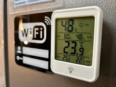 an electronic clock on the wall of a room at Homey 1BR Skyline at Lush Residences, Makati City in Manila