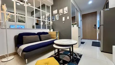 a bedroom with a couch and a table in a room at Homey 1BR Skyline at Lush Residences, Makati City in Manila