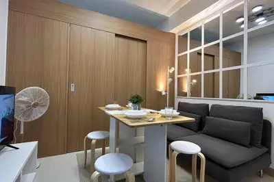 a living room with a table and a couch at Homey 1BR Skyline at Lush Residences, Makati City in Manila