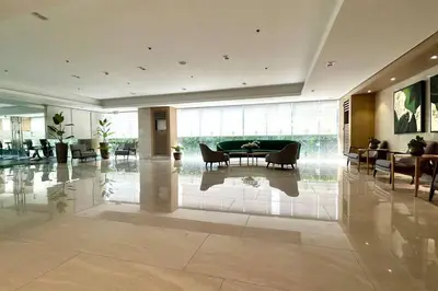 a lobby with a table and chairs in a building at Homey 1BR Skyline at Lush Residences, Makati City in Manila