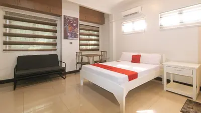 a bedroom with a bed and a chair in it at RedDoorz at MGP Apartelle Near Espana in Manila