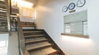 a staircase with two clocks on the wall at RedDoorz at MGP Apartelle Near Espana in Manila