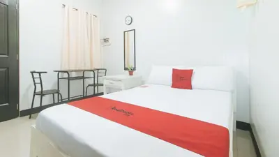 a bedroom with a bed with a red pillow on it at RedDoorz at MGP Apartelle Near Espana in Manila